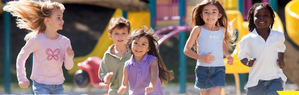 Young children running and laughing together at a playground