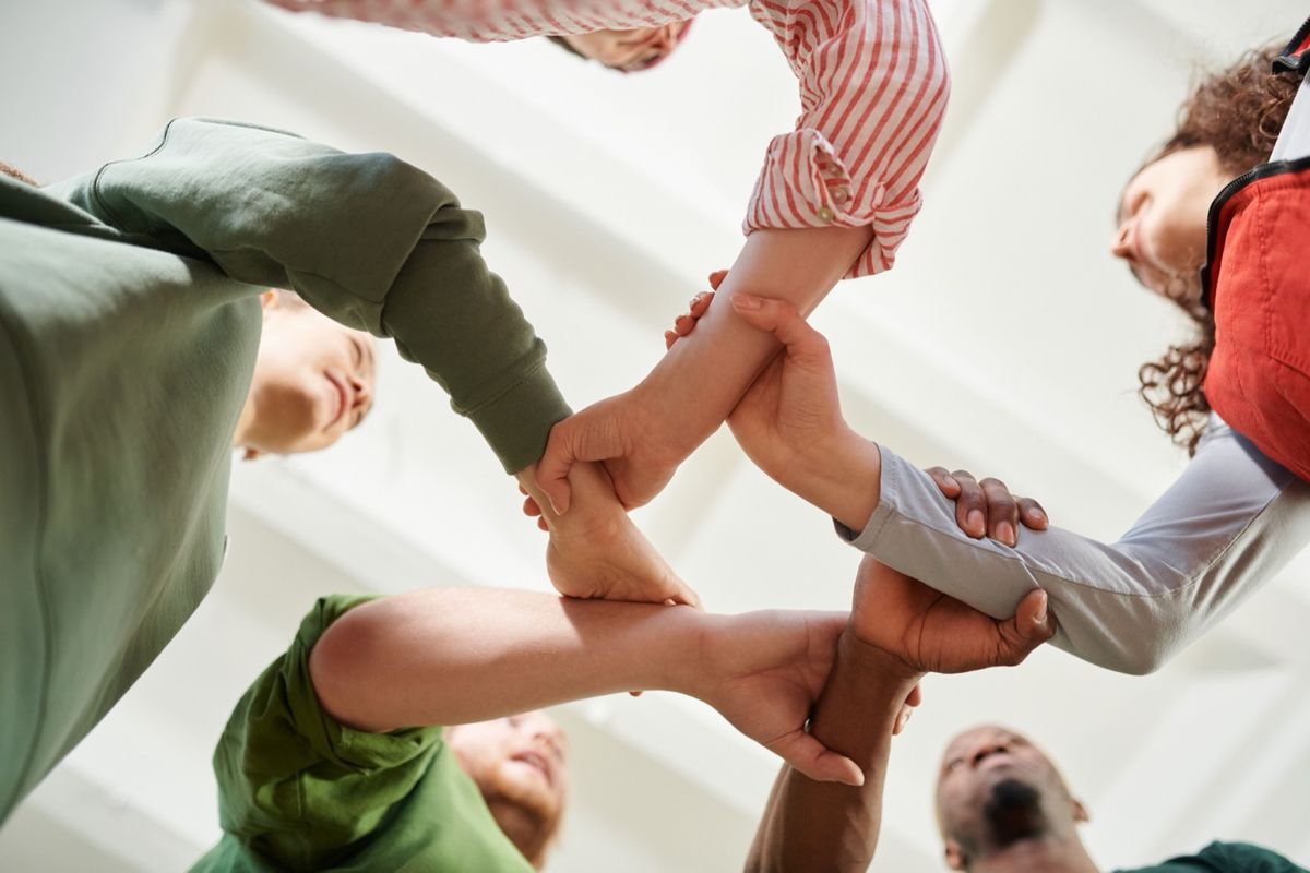 A circle of people holding hands and supporting each other