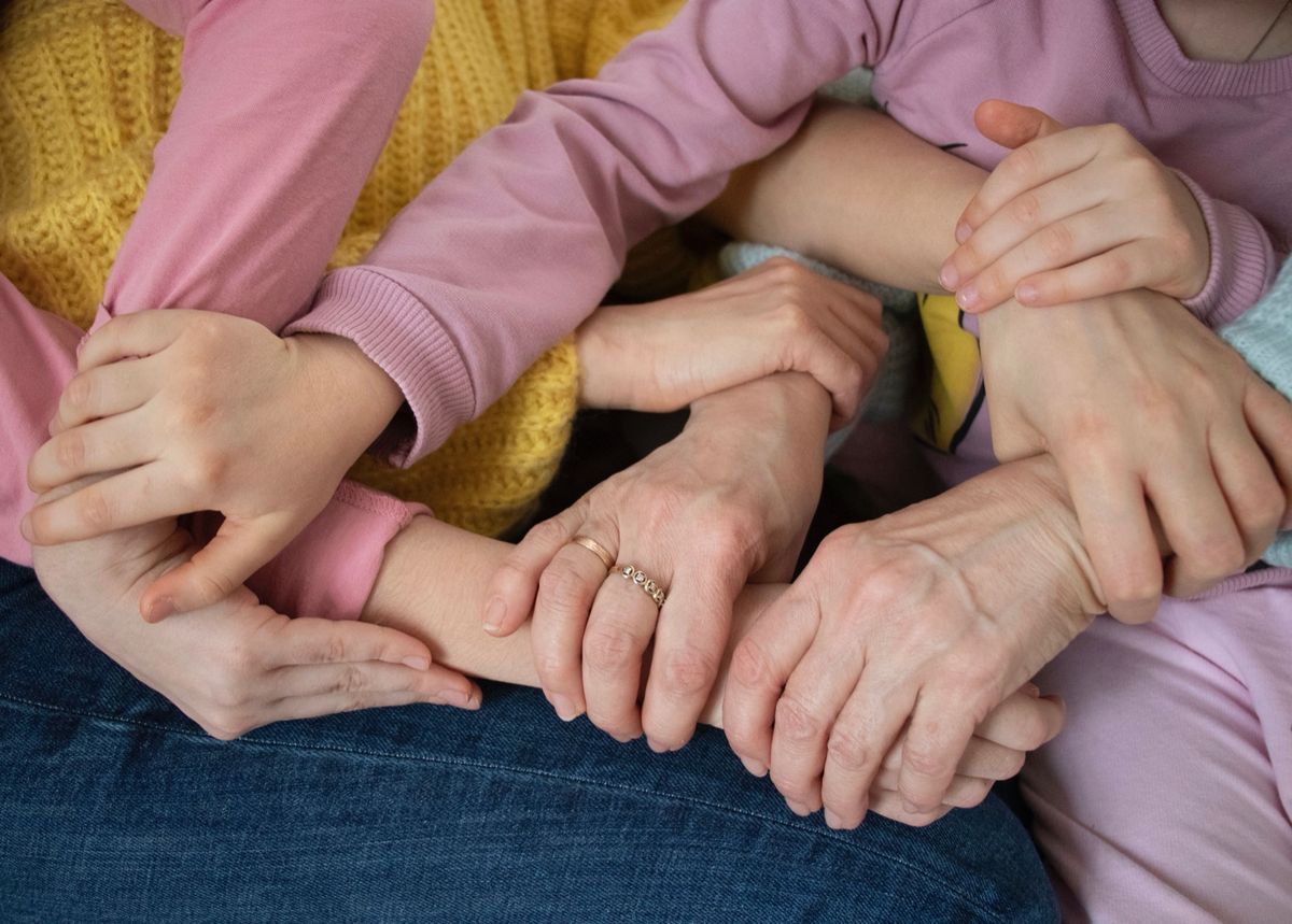A family's hands gently resting and overlapping together